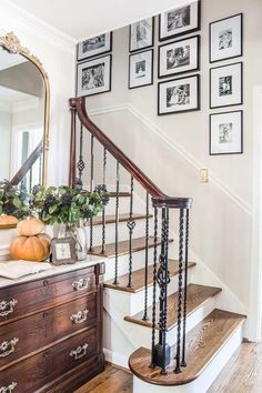 a staircase with pictures on the wall above it and an old dresser in front of it