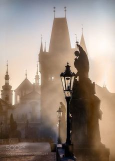 a street light in front of a large building with spires on it's sides