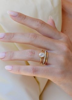 a woman's hand with two rings on it and a diamond ring in the middle