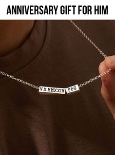 a person holding a silver necklace with the words anniversary gift for him