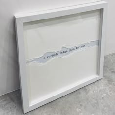 a piece of paper that has been torn in half with the words, is sitting on top of a white frame