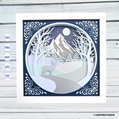 a paper cut out of a snowy mountain scene with trees and mountains in the background