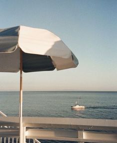 an umbrella and boat on the water from a deck