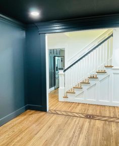 an empty room with stairs and hard wood flooring on the side of the wall