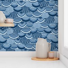 a blue and white wallpaper with an abstract design in the middle, next to a wooden shelf