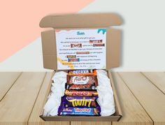 an open box filled with candy on top of a wooden table