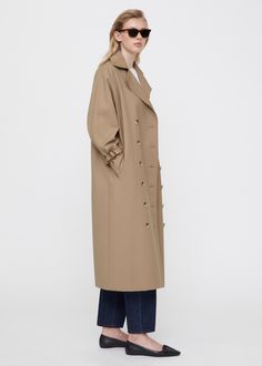 Signature Toteme trench coat made from a durable, water-repellent cotton blend. It’s designed for an oversized fit and shaped to a rounded silhouette with notch lapels, a double-breasted button fastening, buckled cuff straps, slanting side pockets, and a monogram lining. Wear it buttoned up or left open. S Signature, Oversized Silhouette, Welt Pockets, Wear It, Welt Pocket, Repellent, Water Repellent, Horn, Double Breasted