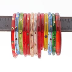 multicolored bracelets are lined up on a ruler