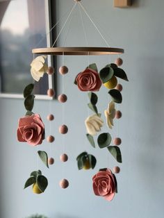 a mobile with flowers hanging from it's sides