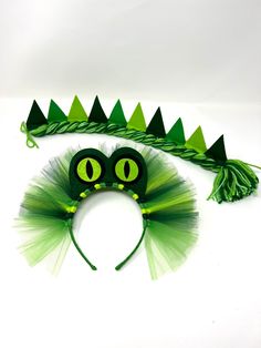 a green and black cat costume with trees on it's head, made out of tulle