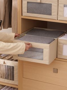 a person is holding a drawer open to show the linens in their storage compartment