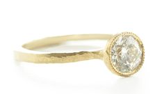 a gold ring with a white diamond in the center