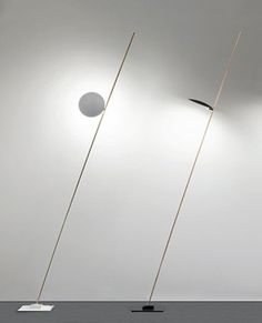 three lamps that are sitting on top of the floor in front of a white wall