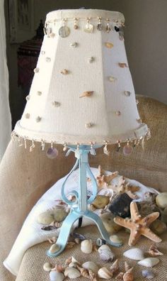 a lamp that is sitting on top of a bed with seashells and starfish