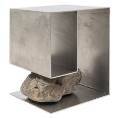 a rock sitting on top of a metal box