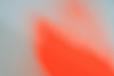 a blurry image of an orange object on a white surface with red and blue colors