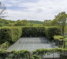 an aerial view of a tennis court surrounded by trees