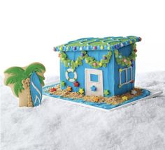 a small blue house with a palm tree on the beach next to it and a cookie