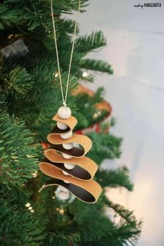 a wooden ornament hanging from a christmas tree with rocks on it's sides