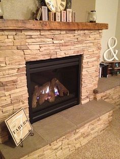 a stone fireplace with a clock on the mantle