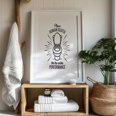 a bathroom with white towels and a wooden shelf next to a green potted plant