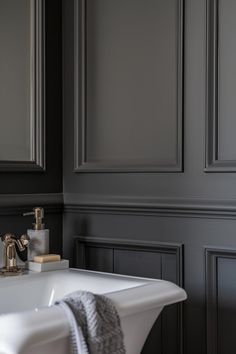 a white bath tub sitting in a bathroom next to a wall mounted faucet