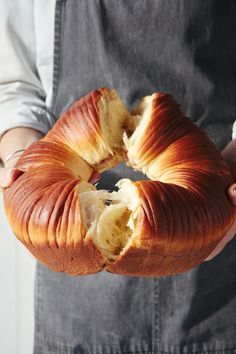 a person holding a large piece of bread in their hands with one bite taken out