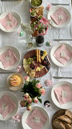 the table is set with pink napkins and plates