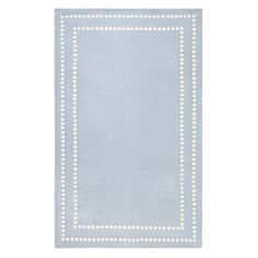 a light blue rug with white dots on the border and a square shape in the middle