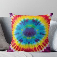 a colorful tie - dyed pillow sitting on top of a couch