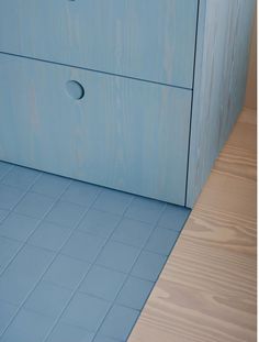 a blue cabinet with two drawers on the bottom and one drawer in the middle is empty