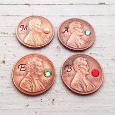 four pennys with different colored stones on them