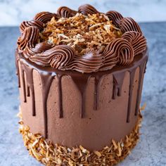 a chocolate cake sitting on top of a table covered in frosting and chopped wood shavings