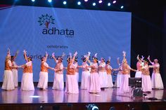 a group of women standing on top of a stage next to each other in front of a screen