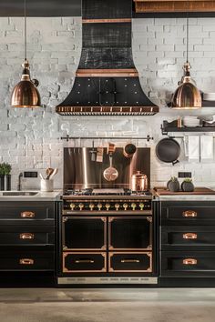 an industrial style kitchen with copper accents and black cabinetry, along with hanging lights