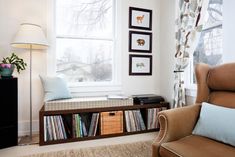 a living room filled with furniture and a book shelf in front of a large window