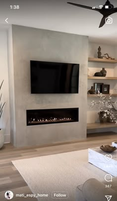 a flat screen tv mounted to the side of a wall next to a fire place