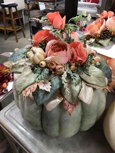 a decorative pumpkin with flowers and leaves on it