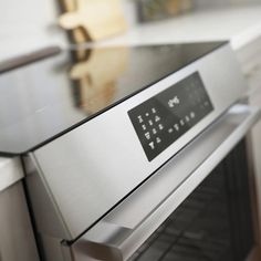 a stainless steel oven with the door open and an electronic display on it's side