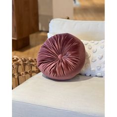 a purple pillow sitting on top of a white couch