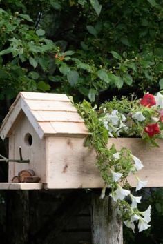 a bird house with flowers growing out of it