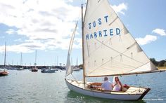 two people in a sailboat with the word just married written on it's side