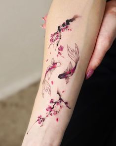 a woman's arm with flowers and fish tattoo on the left side of her body