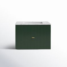 a green and white box sitting on top of a white floor next to a wall