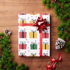 a present wrapped in white paper with red ribbon and bows on it next to christmas decorations