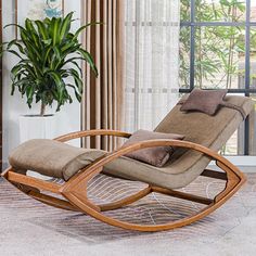 a reclining chair in front of a window with a potted plant next to it