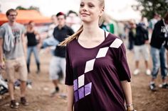 a woman standing in front of a group of people at an outdoor event with her eyes closed