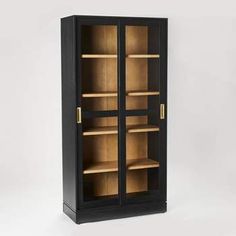 a tall black cabinet with glass doors on the front and bottom shelves in gold trimmings