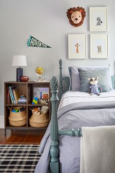 a child's bedroom with blue bedding and pictures on the wall