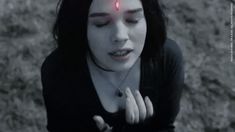 a woman with red eyes is holding her hands out in front of her face and looking at the camera